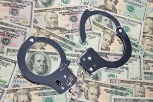 Many dollar bills with handcuffs. Crime and economic crime