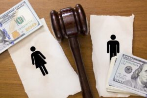 woman and man being divided money from a divorce with judge gavel in middle