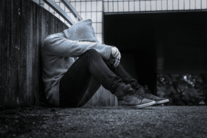 hooded man sitting on the ground. Our lawyers help clients convicted of crimes in related practice areas.